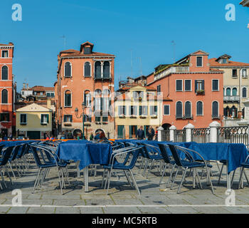 Traditional piazza with tables on terrace in Venice, Veneto, Italy. Identifitable persons purposely blurred Stock Photo