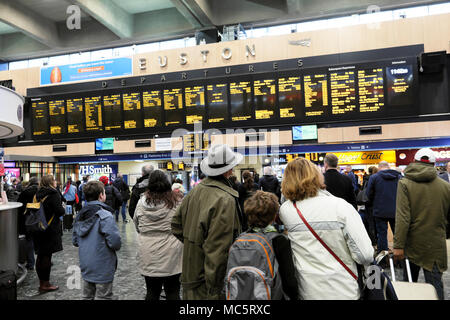 Euston Station crowd & back view of family standing waiting on the busy concourse looking at the departures board in London England UK    KATHY DEWITT Stock Photo