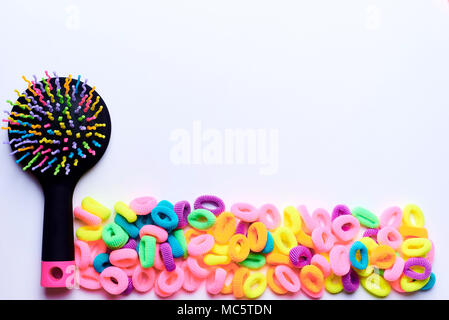 Colorful comb with bright multi-colored elastic bands for hair on a white background.Copy space. Stock Photo