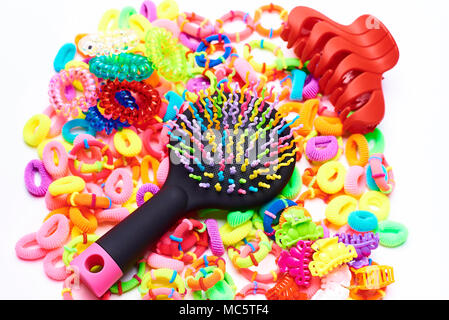 Bright multicolored comb on colored rubber bands for hair on a white background. Stock Photo