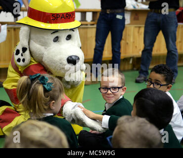 Sparky the Fire Dog, 100th Civil Engineer Squadron Fire Department mascot, greets young students from the Great Heath Academy March 27, 2018 in Mildenhall, England. The firefighters showed the children what their gear is used for, explained how it protects them, and allowed the children to try on the gear. Stock Photo