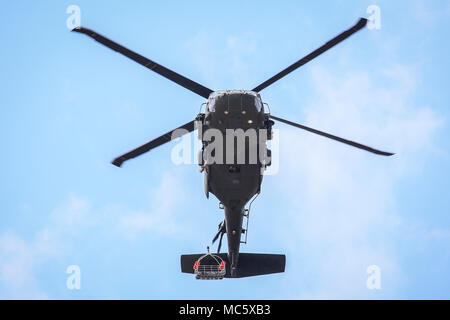 A New Jersey Army National Guard UH-60L Black Hawk helicopter from Det. 2 , C Company, 1-171st Aviation practices with a helicopter rescue basket over Joint Base McGuire-Dix-Lakehurst, N.J., April 11, 2018. The New Jersey National Guard trained with New Jersey Task Force One, an urban search and rescue unit. (U.S. Air National Guard photo by Master Sgt. Matt Hecht) Stock Photo