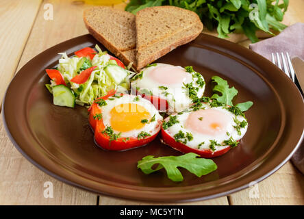 Scrambled eggs baked in a ring bell pepper, toast, arugula leaves and a light salad with cabbage, bell pepper, cucumber. Light breakfast. Stock Photo