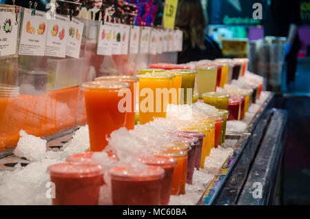 Fruits juices iced and on display for sale at a market stall at La Bocqueria n Barcelona. Stock Photo