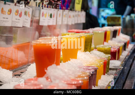 Fruits juices iced and on display for sale at a market stall at La Bocqueria n Barcelona. Stock Photo