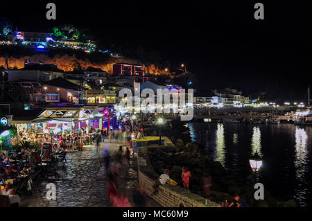 Parga, Epirus - Greece. Nightlife in Parga town during the summer. Tourists enjoying their holidays having a drink, eating greek traditional food Stock Photo