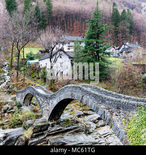 view of the old Roman stone bridge with two arches near the village of Lavertezzo in the Swiss Alps Stock Photo