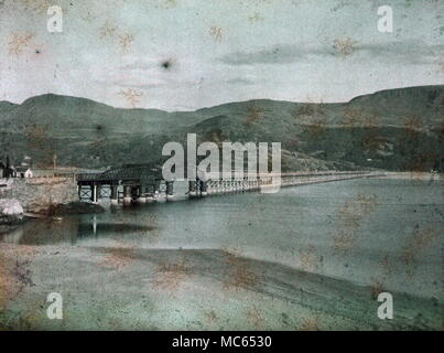 AJAXNETPHOTO. 1911 (APPROX). BARMOUTH, MERIONETHSHIRE, WALES, UNITED KINGDOM. - LOOKING ACROSS THE MAWDDACH ESTUARY WITH THE RAILWAY BRIDGE; VIEW MADE WITH EARLY AUTOCHROME COLOUR FILM.  PHOTOGRAPHER:UNKNOWN © DIGITAL IMAGE COPYRIGHT AJAX VINTAGE PICTURE LIBRARY SOURCE: AJAX VINTAGE PICTURE LIBRARY COLLECTION REF:(C)AVL ACHM 1911 26 Stock Photo