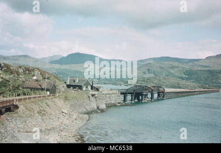 AJAXNETPHOTO. 1930S (APPROX). BARMOUTH, MERIONETHSHIRE, WALES, UNITED KINGDOM. - LOOKING ACROSS THE ESTUARY WITH THE RAILWAY BRIDGE; VIEW MADE WITH EARLY DUFAY COLOUR FILM.  PHOTOGRAPHER:UNKNOWN © DIGITAL IMAGE COPYRIGHT AJAX VINTAGE PICTURE LIBRARY SOURCE: AJAX VINTAGE PICTURE LIBRARY COLLECTION REF:(C)AVL DUF 1911 02 Stock Photo