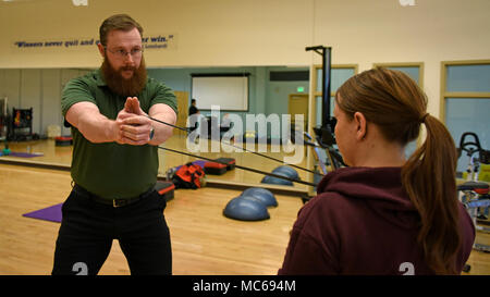 Justin Clifford, 92nd Medical Operations Squadron physical therapist, demonstrates resistance band training to Staff Sgt. Jamie Skrainka, 92nd Maintenance Squadron Human Performance Cell patient, at Fairchild Air Force Base, Washington, Feb. 26, 2018. Starting in October, all military members who have been non-deployable for more than 12 consecutive months, for any reason, will be processed for administrative separation. The HPC program’s objective is to reduce the number of non-deployable service members and improve personnel readiness across the force. Stock Photo
