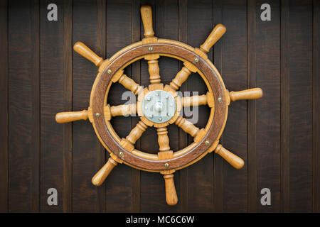 Wooden metal old wheel steering on wood background. Stock Photo