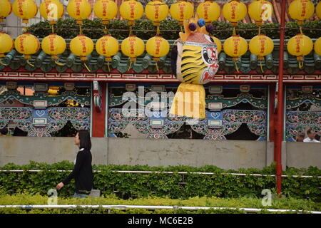 Asian woman walking beside yellow lanterns outside Longshan buddhist temple, Taipei - Taiwan Stock Photo