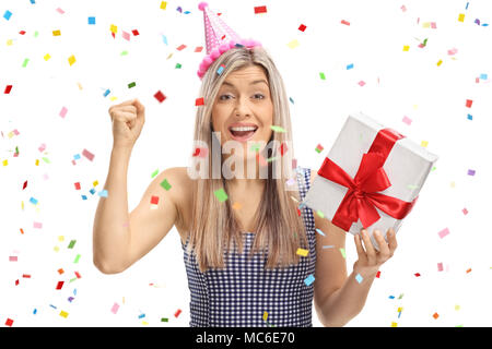 Joyful young woman holding a present with confetti streamers flying around her isolated on white background Stock Photo