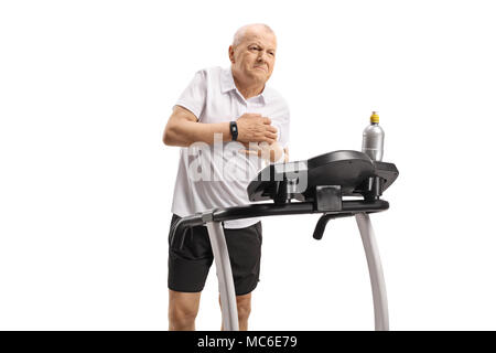 Mature man on a treadmill having a heart attack isolated on white background Stock Photo