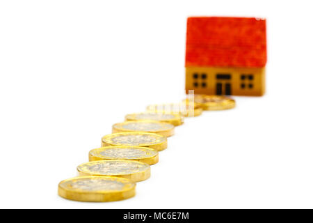Path of money new pound £ coins pounds GBP leading to a house to illustrate property prices values and saving for a home ownership concept. UK Britain Stock Photo