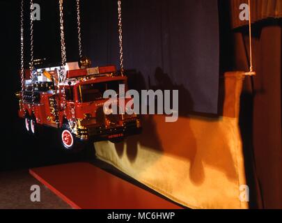 Disappearing Fire engine trick. This picture shows what the magician sees - the black hiding curtain which allows the fire engine to be lifted by crane. Stock Photo