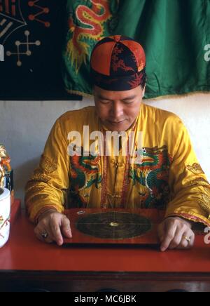 FENG SHUI. Chinese diviner using the geomancer compass, the Lo Pan, to determine directions and distances Stock Photo