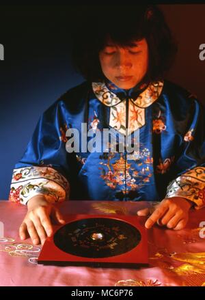 Feng Shui Chinese girl with a Luo Pan, or Feng Shui compass, of Taiwan manufacture Stock Photo