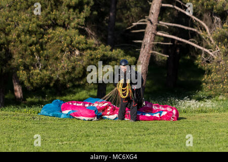 Drama, Greece -  April 8, 2018: Man with a paraglider on a green field after landing waving Stock Photo