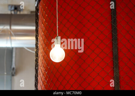 Lighting decor . lighted bulb with red wall as a background Stock Photo