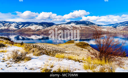 Snow Covered Mountains surrounding Kamloops Lake in central British Columbia, Canada on a cold and crisp Winter Day under a blue sky Stock Photo