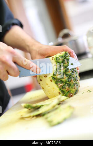 Cook cutting a pineapple Stock Photo