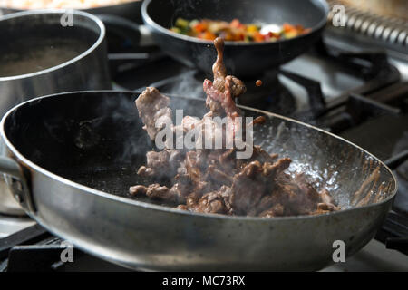 closeup of a chef cooking Beef strips in a pan with red wine Stock Photo
