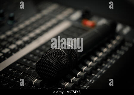 Microphone laying on a mixing desk mixer close Stock Photo