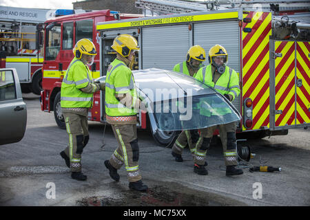 group of firemen cutting roof from car Stock Photo