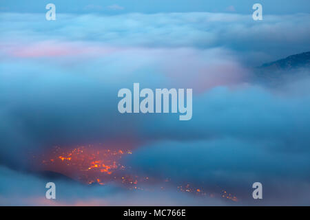 Bird's eye view on Faraya mountain, Lebanon, amazing view from above through clouds on mountainous city, glowing lights from the homes windows at nigh Stock Photo