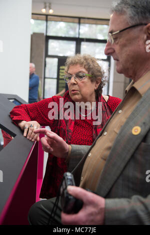 13 April 2018, Germany, Lohheide: Lous Steenhuis-Hoepelman (L) and Ivan Lefkovitz, who were child inmates in Bergen-Belsen, looking at the exhibition 'Kinder im KZ Bergen-Belsen' (lit. children in Bergen-Belsen). The doll was the only thing she had with her in the camp. From the approximaately 120 000 detained people at the concentration camp in the Lueneberg Heath, from all parts of Europe, there were also around 3500 children under 15 years of age. Photo: Philipp Schulze/dpa Stock Photo
