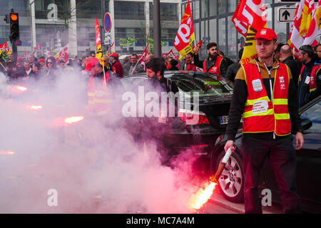 Lyon, France, 13th April 2018: Called by trade unions, SNCF employees are seen in Lyon (Central-Eastern France) on April 13, 2018 as they stand, holding flares, in Part-Dieu area on the fifth day of action against status reform engaged by French Government.  Credit: Serge Mouraret/Alamy Live News Stock Photo