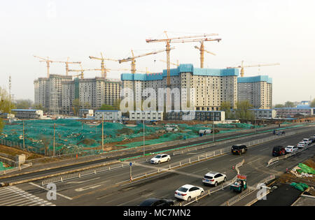 View of construction site of new residential blocks near Baiziwan metro station in eastern Beijing, China, with mesh ground-cover to reduce blown dust Stock Photo