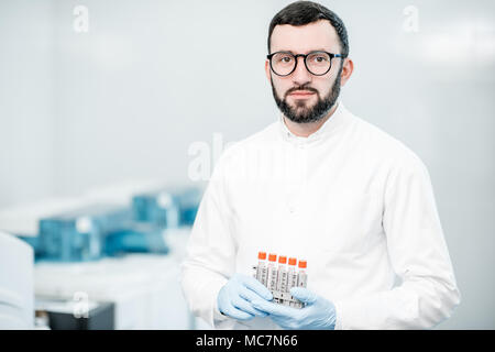 Portrait of a male technician standing with test tubes in the laboratory Stock Photo