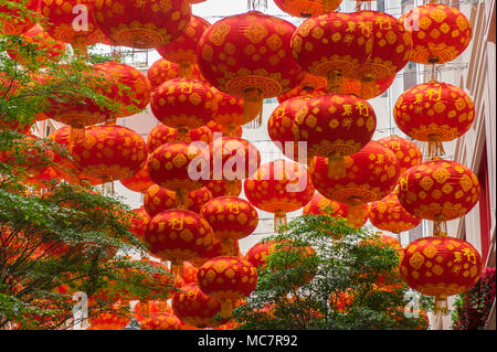 Traditional Chinese red lanterns with skyscrapers on background. Contrast of ancient tradition and modern life in South East Asia. China, Hong Kong. Stock Photo