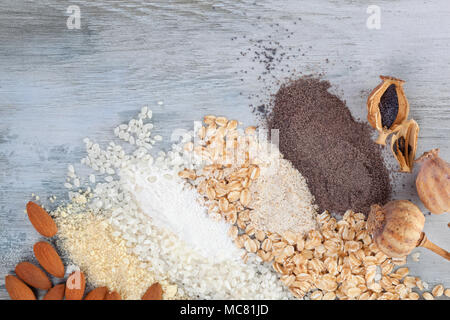 Various types of gluten free flours on wooden table from above. Almond, rice, oat and poppy flour. Stock Photo