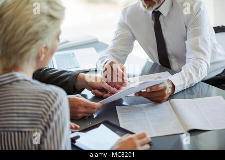 Businessman explaining document to colleagues Stock Photo