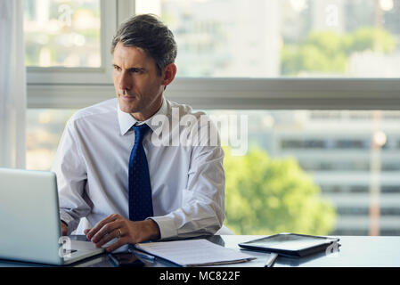 Man using laptop computer in office Stock Photo