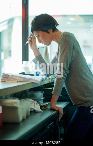 Cafe manager assessing finances Stock Photo