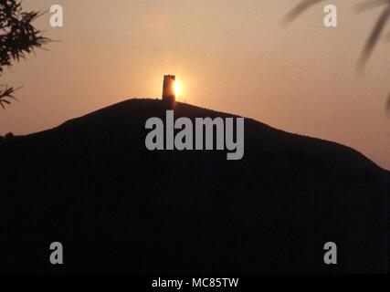 GLASTONBURY Glastonbury Tor, with the tower of St Michael's church at sunset. Arthur was said to have been buried in the Abbey below Stock Photo