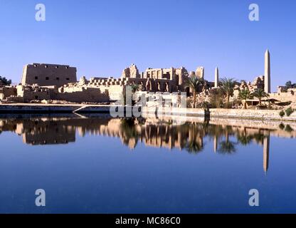 The sacred pool at Karnak, with the temple of Amun reflecting in its surface. Egypt Stock Photo