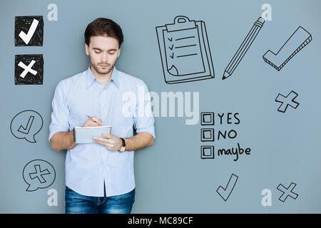 Concentrated manager holding a notebook and making a research Stock Photo