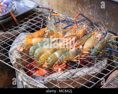 Prawns cooking on a charcoal grill on a street food stall in Bangkok Thailanad Stock Photo