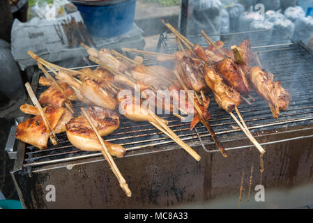 Chicken wing street food cooking on a charcoal grill in Bangkok Thailand Stock Photo