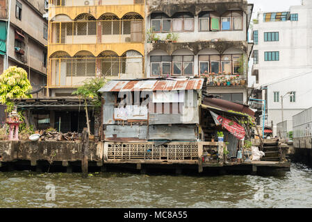 Rickety old buildings made from corrugated iron and wood alongside the Chao Phraya River in Bangkok, Thailand Stock Photo