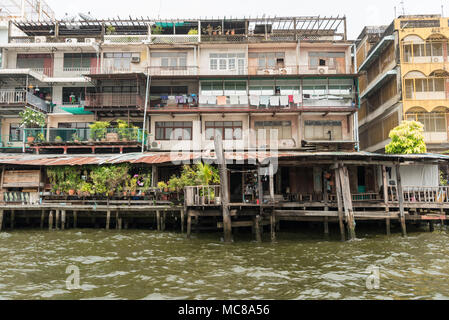 Rickety old buildings made from corrugated iron and wood alongside the Chao Phraya River in Bangkok, Thailand Stock Photo