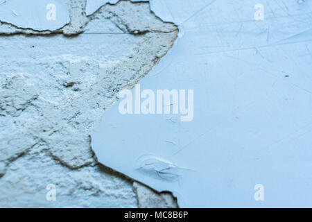 Grey grunge background. Old surface with pieces of peel-off paint and putty. Stock Photo