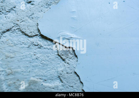Grey surface with pieces of peel-off paint and putty. Selective focus and copy space. Stock Photo
