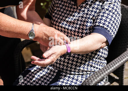 old womans is having wearable device smart watch in care home retirement house. Stock Photo