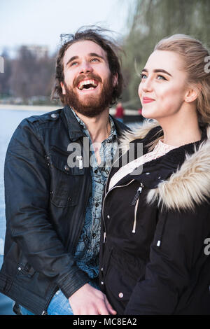 Portrait of a young couple laughing with open mouth and looking up Stock Photo
